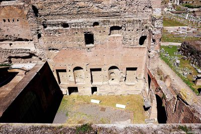 Widok ze zboczy Palatynu na ruiny budowli z czasów cesarza Domicjana (dziedziniec przed kościołem Santa Maria Antiqua). Po prawej - Forum Romanum. Prostokątny ślad na dziedzińcu to obrys dawnego basenu zdobiącego pałac Kaliguli. Jak widać, basen był zorientowany według innych osi niż budowla Domicjańska. To pokazuje, że cesarz Domicjan zburzył pałac Kaliguli i na jego fundamentach zbudował zupełnie nowy kompleks budynków.