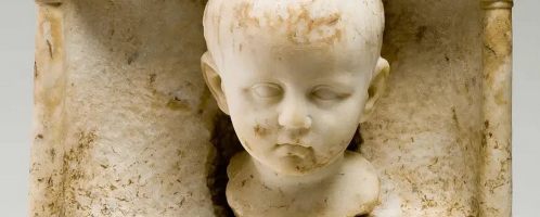 Rzeźbiony detal na rzymskim nagrobku ukazujący głowę 4 letniego Tiberiusa Natroniusa Venustusa