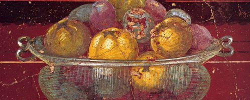 Szklane naczynie z granatami i jabłkami na fresku