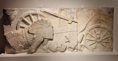 Marmurowy relief ukazujący powalonych katafraktów i zniszczone rydwany